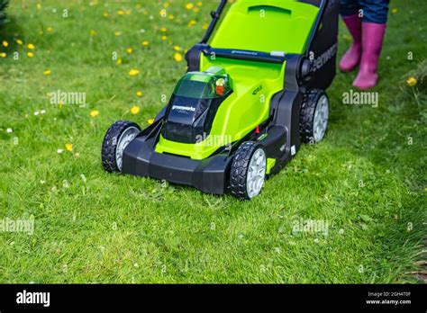Thematic photo of a person effortlessly mowing a lawn with a cordless lawnmower