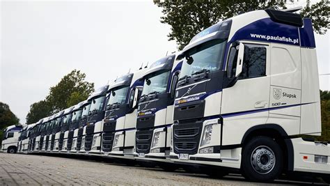 Zdjęcie przedstawiające różne modele ciągników siodłowych Volvo FH w ruchu lub na parkingu