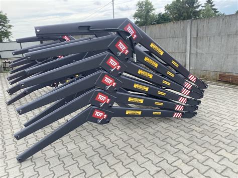Zdjęcie przedstawiające ładowacz AGRO-TUR podczas pracy przy transporcie balotów