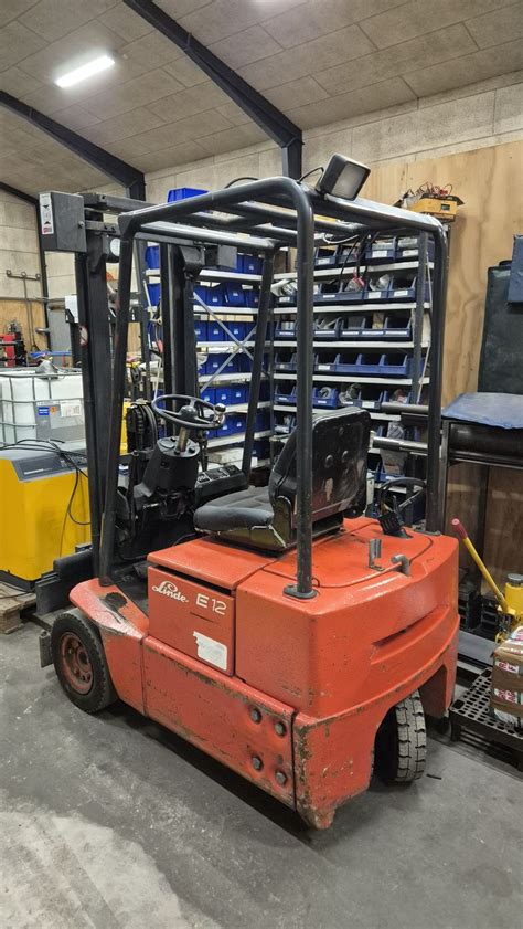 Mechanik naprawiający wózek widłowy w serwisie