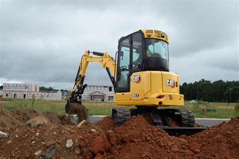 Thematyczne zdjęcie minikoparki Cat 303 CR w akcji na placu budowy