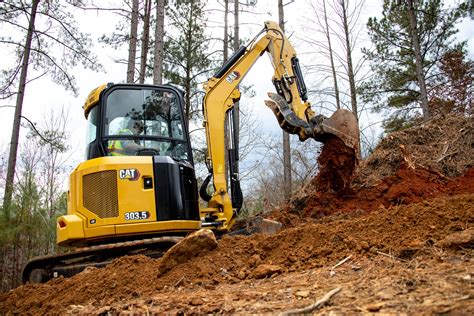 Wnętrze kabiny minikoparki Cat 303 CR z widocznym monitorem i elementami sterowania
