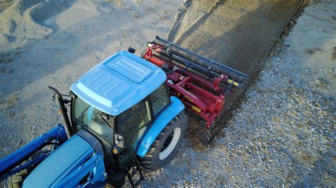 Thematic photo of a stone burier attached to a tractor working in a field