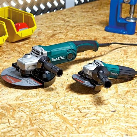 Tematyczne zdjęcie szlifierek kątowych Makita i JCB obok siebie na tle warsztatu