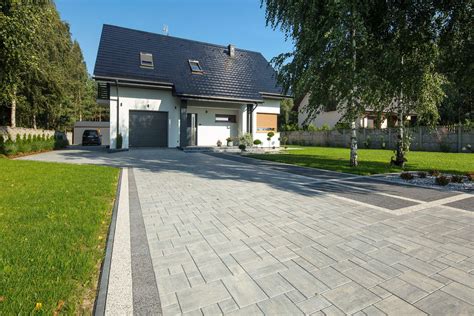 Zdjęcie przedstawiające przykładowy wzór ułożenia klasycznej kostki brukowej z przerwami wypełnionymi trawą