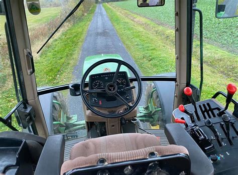 Wnętrze kabiny John Deere 6100 D z widokiem na panel sterowania i kierownicę