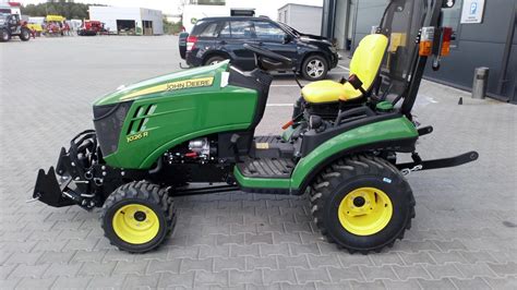 Traktor ogrodowy John Deere z podłączonym osprzętem