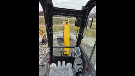 Wnętrze kabiny nowoczesnej koparki, prezentujące ergonomiczne sterowanie, wygodne siedzenie i systemy bezpieczeństwa.