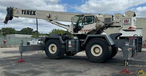 The Terex RT 160 crane performing a lift operation, with its outriggers extended and boom raised.