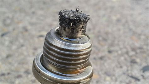 Photo of a magnetic drain plug with metallic debris, illustrating diagnostic indicators.