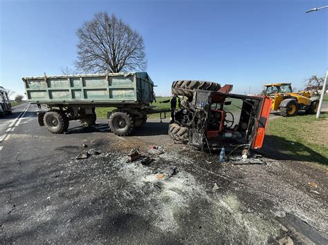 Zdjęcie ciągnika rolniczego z przyczepą wykonującego manewr na placu