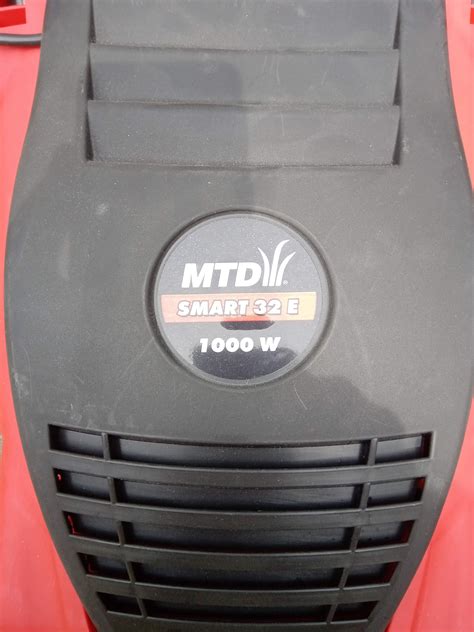 zdjęcie kosiarki elektrycznej MTD Smart 32 E pokazujące jej kompaktowe rozmiary i uchwyt do przenoszenia