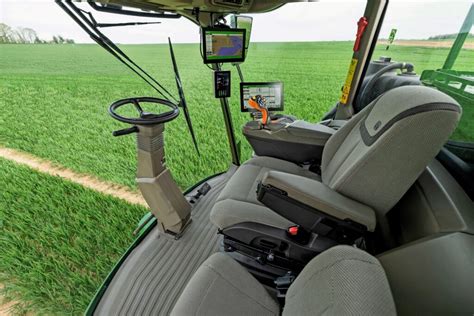 Wnętrze kabiny opryskiwacza John Deere 500R z widocznym dużym wyświetlaczem i ergonomicznym panelem sterowania.
