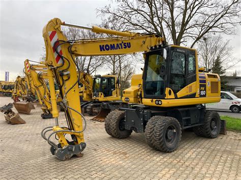 Zdjęcie koparki kołowej Komatsu PW 180-11E0 pokazujące jej konstrukcję i osprzęt.