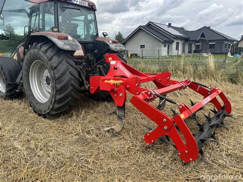 Zdjęcie przedstawiające głębosz w akcji na polu rolnym, z widocznymi rozluźnionymi warstwami gleby