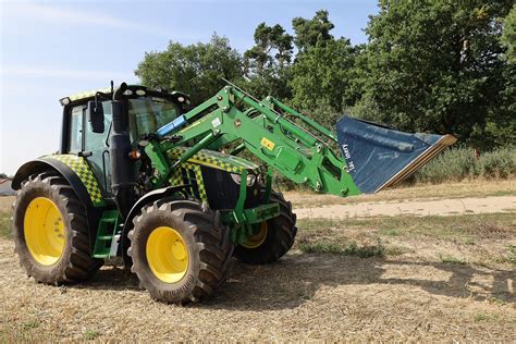 zdjęcie ciągnika John Deere 6120M z zamontowanym ładowaczem czołowym