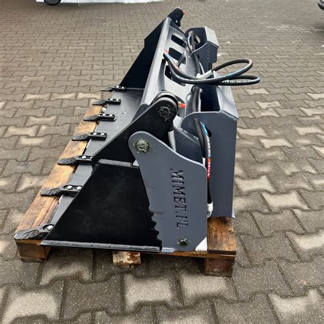 Wielofunkcyjna łyżka Bobcat z hydraulicznym otwieraniem, umożliwiająca kopanie, niwelowanie i chwytanie.