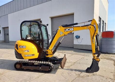 Porównanie wizualne minikoparki JCB 8018 z JCB 8026 CTS, z zaznaczonymi potencjalnymi różnicami w konstrukcji.