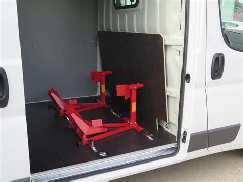 Zdjęcie rozkładanego stołu warsztatowego zamontowanego na ścianie grodziowej w samochodzie dostawczym