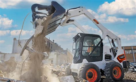 zdjęcie miniładowarki Bobcat pracującej na placu budowy