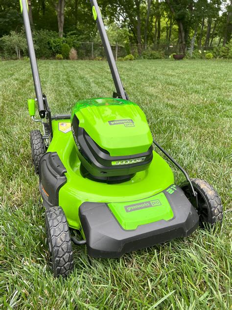 Thematic photo of an electric lawn mower on a green lawn