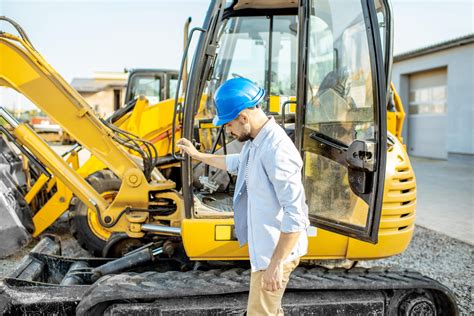 Operator koparki sprawdzający poziom oleju hydraulicznego