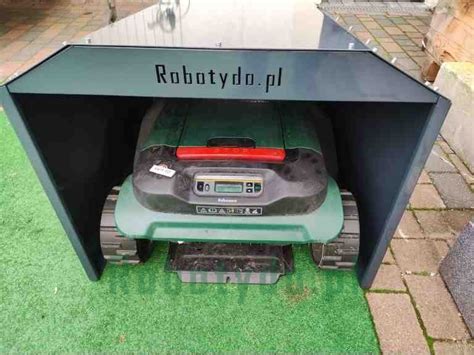 stacja ładująca robota koszącego w osłoniętym miejscu