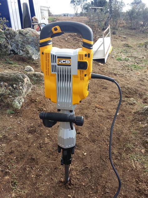 The JCB DRH 1750W 45J demolition hammer in action, breaking concrete.