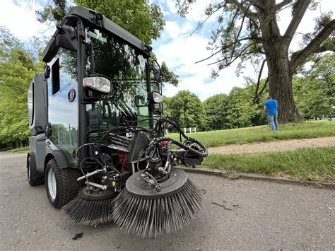 Schematyczna ilustracja zamiatarki komunalnej Profi Clean z zaznaczonymi głównymi elementami roboczymi i zbiornikiem.