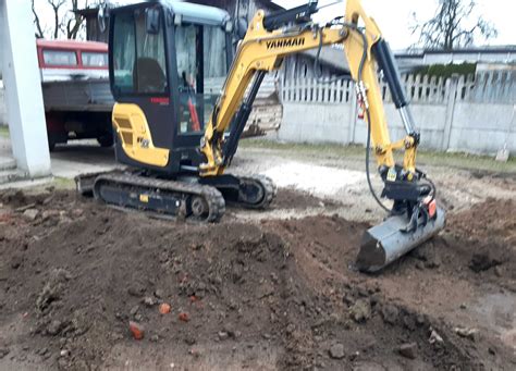 Minikoparka wykonująca prace ziemne na działce