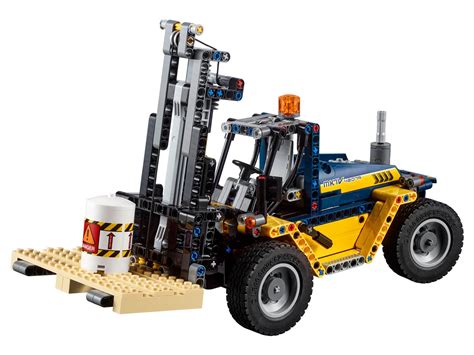 The LEGO Technic 42079 forklift with its forks raised and a pallet. The image should highlight the yellow and blue color scheme, large tires, and detailed driver's cab.
