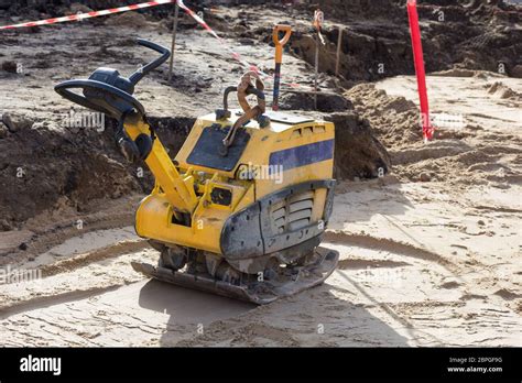 Thematic photo of a construction site with a plate compactor working on soil compaction
