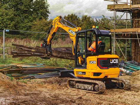 Thematic photo of a JCB mini-excavator with a grapple attachment in action on a construction or demolition site