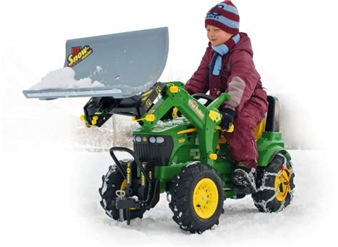 zdjęcie dziecka odśnieżającego śnieg traktorkiem Rolly Toys z pługiem RollySnow Master