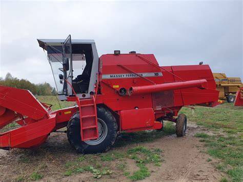 Kombajn Massey Ferguson 16 podczas koszenia zboża na polu, z widoczną czerwoną konstrukcją i hederem z motowidłami
