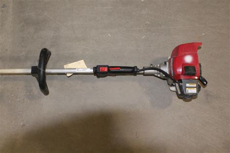 Thematic photo of a person using a Kawasaki string trimmer in a garden