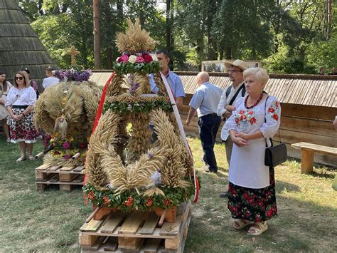 Uczestnicy barwnego korowodu dożynkowego z wieńcami i maszynami rolniczymi