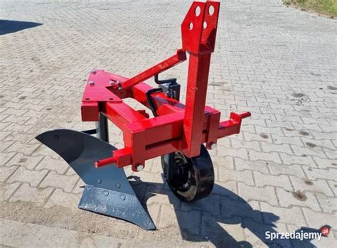 Pług jednoskibowy podłączony do mini traktorka, w akcji na polu