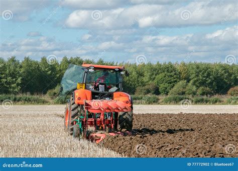 Thematic photo of a Kubota tractor with a rotary plough working in a field