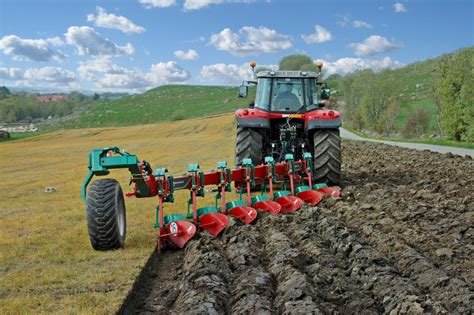 Thematic photo of various Kverneland plows in a field, showing different types and sizes