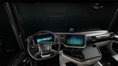Wnętrze kabiny Scania R, prezentujące ergonomiczną deskę rozdzielczą i komfortowe łóżko
