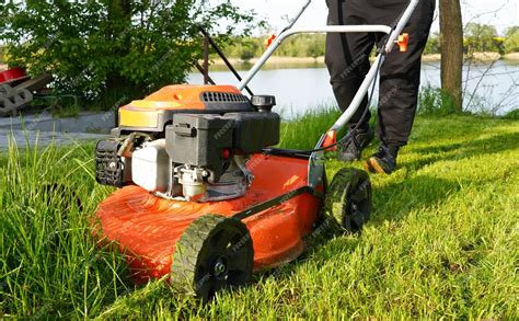 Thematic photo of a person mowing a lawn with a Faworyt gasoline lawnmower with Briggs & Stratton engine