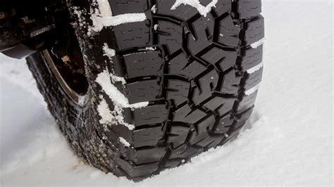 Close-up photo of snow blower's tires with aggressive tread and adjustable skid shoes