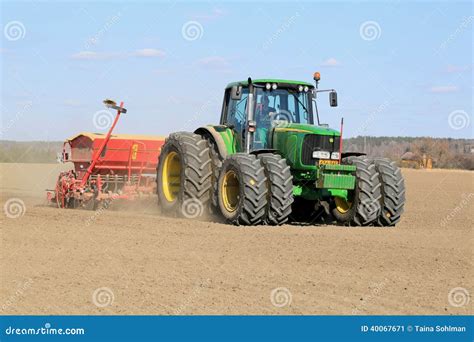 Thematic photo of a tractor working in a field with a raised seeder