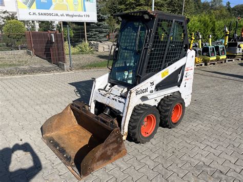 Zabytkowa miniładowarka Bobcat i współczesny model w pracy