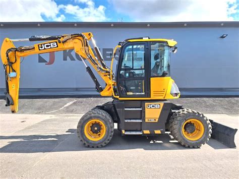 Infografika prezentująca kluczowe zalety koparki JCB HD110WT 4F Hydradig: widoczność, stabilność, manewrowość.