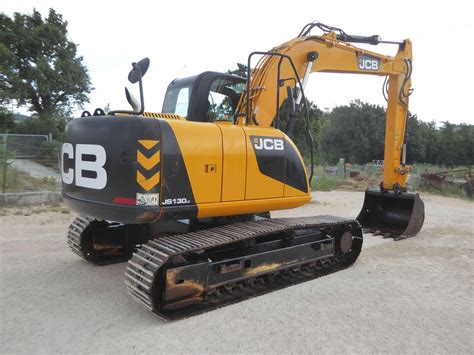 Schemat porównujący zasięg kopania i głębokość kopania modeli JCB JS 130 i Liebherr 311/312.
