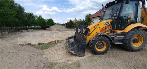Koparko-ładowarka wykonująca prace ziemne na placu budowy