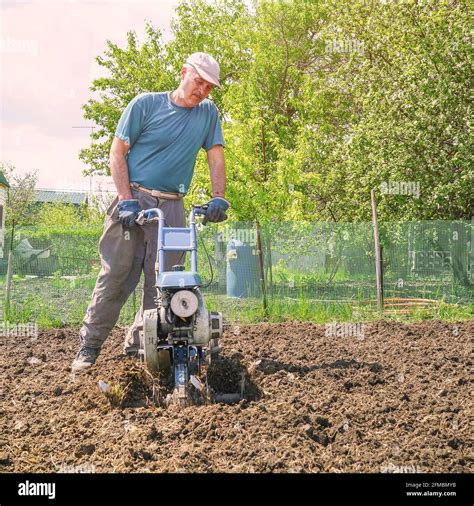 Thematic photo of a person using a garden tiller in a field