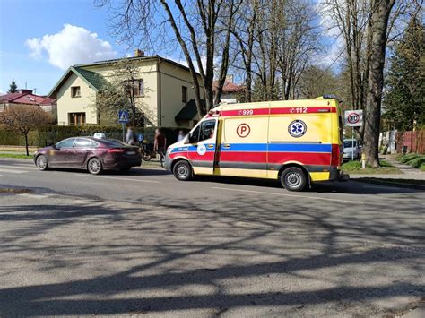 Zabezpieczona przewrócona minikoparka leżąca na boku, wokół której pracują służby ratunkowe